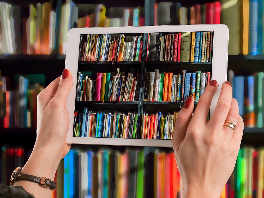 Tablet fotografiert Bücher aus dem Bücherregal