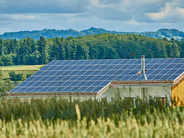 Ein Dach mit Solaranlage in grüner Landschaft © RoyBuri, pixabay