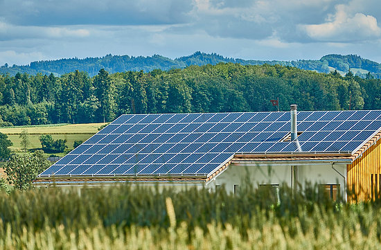 Ein Dach mit Solaranlage in grüner Landschaft © RoyBuri, pixabay